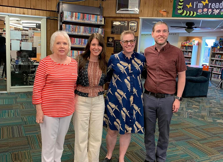 Elizabeth Tackett, Mackenzie New Walker, Emily Drabinski, and Thomas Jude pose with smiles at the Buffalo Creek Public Library in Man, West Virgina 