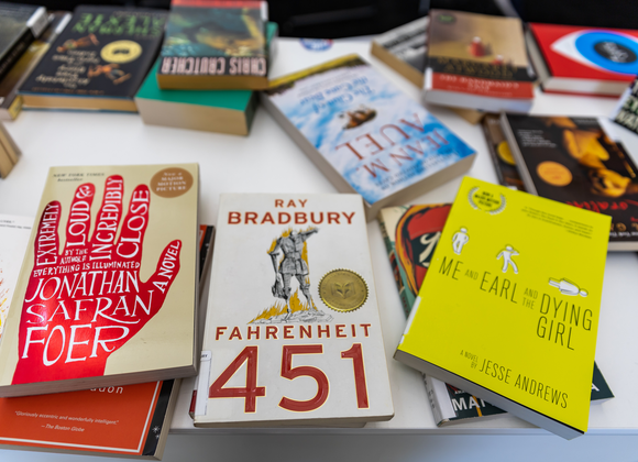 A collection of banned and challenged books on display at a conference table