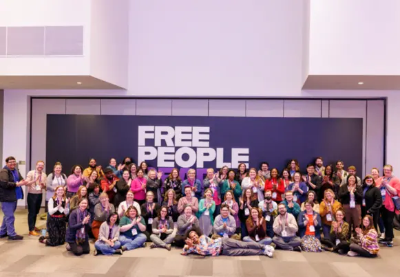 Photo of a large group of PLA 2024 Conference attendees in front of the "Free People Read Freely" wall