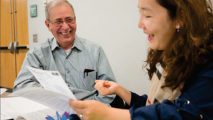 Two people lightheartedly discussing a paper